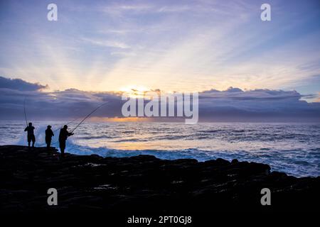 Amici che pescano dall'oceano a Orange Rocks sulla costa meridionale di Margate in Sudafrica Foto Stock