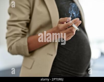 La vostra salute dei bambini è fondamentale. una donna che fuma una sigaretta mentre si è in preda Foto Stock