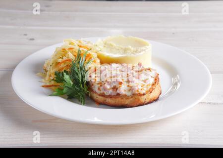 Cotoletta di pesce con prosciutto e formaggio fuso topping servita con cavolo sott'aceto e purea di patate Foto Stock