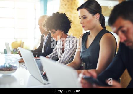 Come i professionisti ambiziosi. colleghi che lavorano alla scrivania in un ufficio Foto Stock