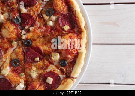 Pizza con le salsicce, prosciutto, pomodori, zucchine e paprica Foto Stock