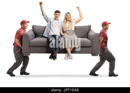 Movers che trasportano una giovane coppia seduta su un divano grigio e la felicità gesturing isolata su fondo bianco Foto Stock