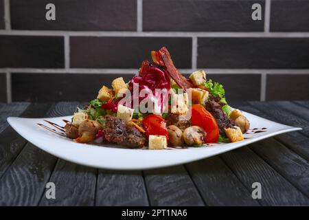 Con insalata di fegato, bacon, grigliate di pomodoro e pepe con cavolo rosso e funghi Foto Stock