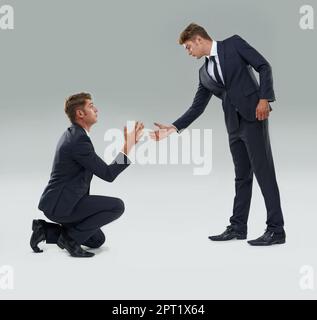 A volte solo tu puoi aiutare te stesso... Un bel uomo d'affari che aiuta il suo alter ego fuori terra Foto Stock