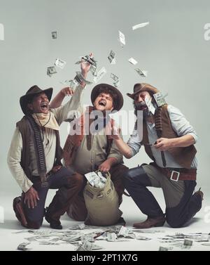 Tira di un selvaggio lavoro della banca occidentale. Un gruppo di banditi che festeggiano una rapina insieme Foto Stock