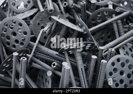 La configurazione di sfondo di molti in plastica grigia (spine di fissaggio) per isolamento termico. Un enorme pila di attrezzature per l'installazione di polystiren espanso Foto Stock