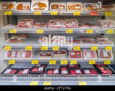 Torino, Italia - 27 aprile 2023: Scaffale refrigerato con carne fresca confezionata in vendita al supermercato italiano, confezioni sottovuoto di manzo, maiale, pollame con p Foto Stock