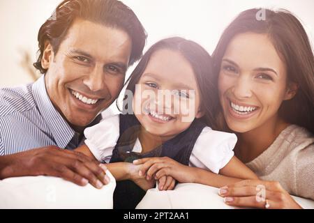 E tre fanno una famiglia. Ritratto corto di una giovane coppia affettuosa che si rilassa a casa Foto Stock