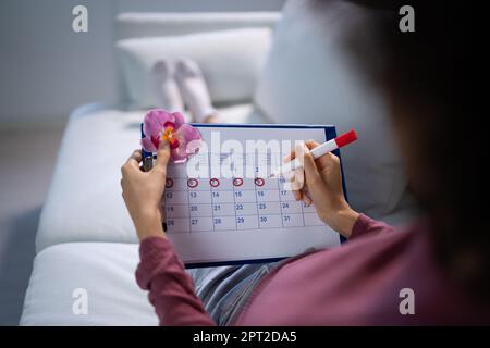 Donna africana che usa il ciclo mestruale o il calendario del periodo Foto Stock