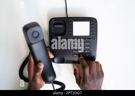 Numero di telefono per la composizione a mano di un uomo d'affari per effettuare una chiamata telefonica Ufficio Foto Stock