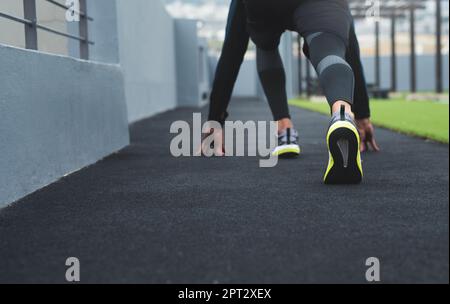 Preparati e preparati a partire. Primo piano di un uomo sportivo in posizione di partenza mentre si pratica all'aperto Foto Stock