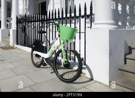 Bici di calce lasciata su un marciapiede da ringhiere a Bayswater, Londra, Inghilterra. Foto Stock