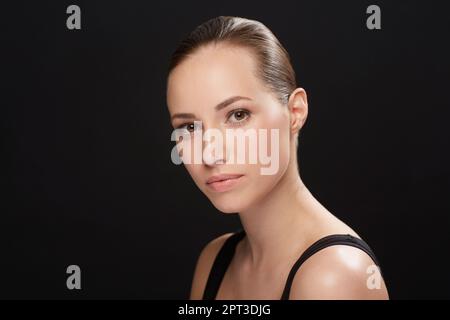 Ceneri serio circa avere buona pelle. Una giovane donna naturalmente bella isolata su uno sfondo nero - tagliata Foto Stock