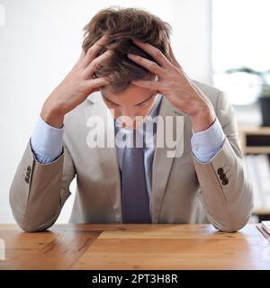 E a volte le cose vanno terribilmente male... Un giovane uomo d'affari seduto alla sua scrivania con la testa nelle sue mani Foto Stock