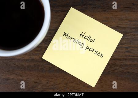 Ciao mattina persona testo sulla nota adesiva con una tazza di caffè Foto Stock