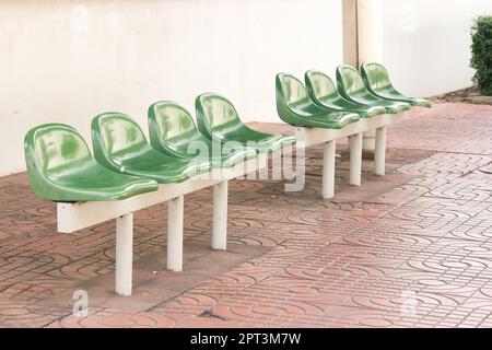 Sedia di plastica verde alla fermata dell'autobus per i passeggeri in attesa Foto Stock