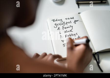 Concetto di giornale di gratitudine. Scrittura sono grato in giornale Foto Stock