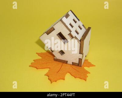 Si trova una casa capovolta su una foglia d'acero Foto Stock