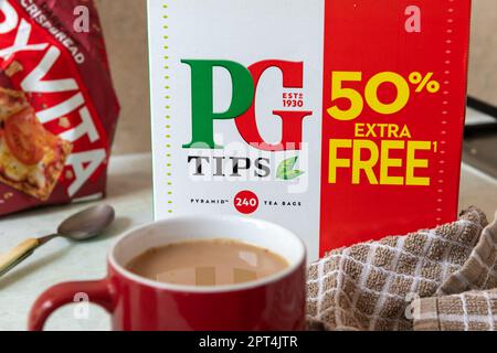 Londra. UK- 04.19.2023. Una scatola di jumbo di sacchetti da tè PG Tips con una tazza di tè al latte. Foto Stock