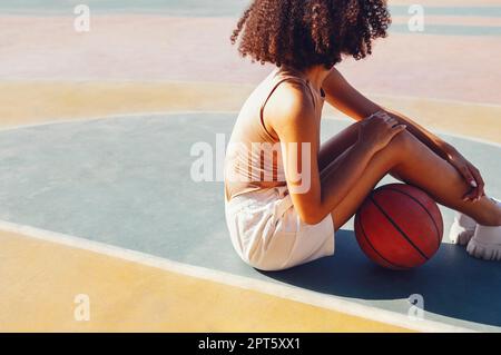 Giovane giovane donna sorridente di corsa mista all'aperto e divertente. Elegante giovane ragazza cool riunirsi al campo da basket, giocare a basket all'aperto Foto Stock