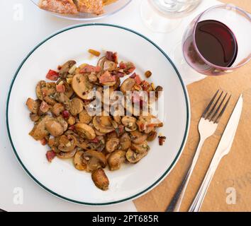 Funghi saltati serviti su piatto bianco Foto Stock
