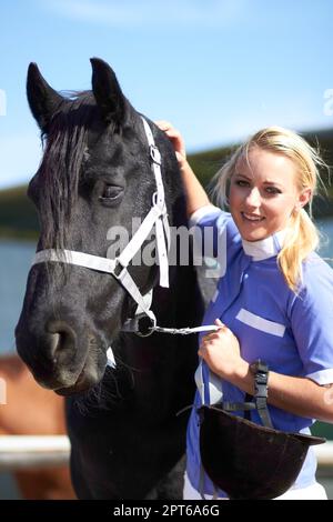 HES più di un semplice animale per me. una bella giovane donna in piedi accanto al suo cavallo Foto Stock