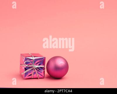 Confezione regalo rosa con babble natalizio su sfondo rosa con spazio per il testo o l'immagine Foto Stock