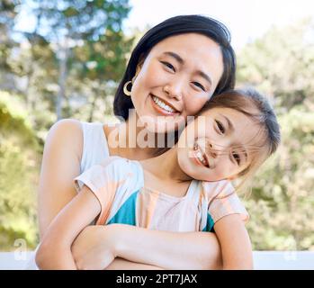 Non posso abbracciarla abbastanza duramente. una adorabile bambina e sua madre abbracciano in giardino Foto Stock