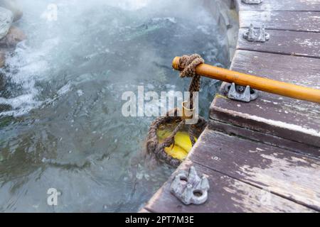 Cucinate mais e uova all'interno di un cesto in una sorgente calda a Jioujhihze di Taipingshan a Taiwan Foto Stock
