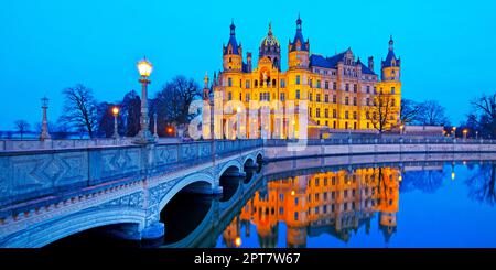 Castello di Schwerin illuminato con il ponte del castello per l'isola del castello in serata, Schwerin, Meclemburgo-Pomerania occidentale, Germania Foto Stock