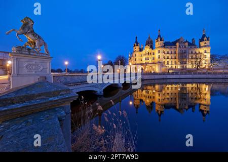 Castello di Schwerin illuminato con il ponte del castello per l'isola del castello in serata, Schwerin, Meclemburgo-Pomerania occidentale, Germania Foto Stock