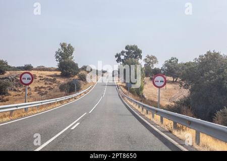 Segnali che indicano il divieto di sorpasso. Strada locale con cambi di pendenza costanti Foto Stock