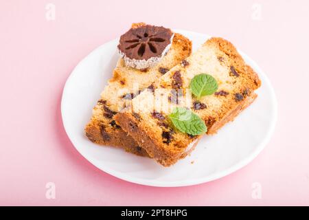 Torta fatta in casa con uvetta e persimmon secco su sfondo rosa pastello. Vista laterale, primo piano, spazio di copia. Foto Stock