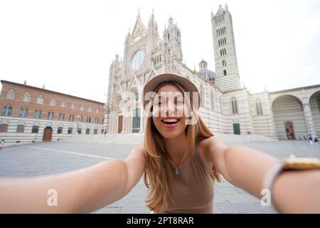 Vacanze in Italia. Ragazza brasiliana scatta foto selfie con smartphone a Siena, Toscana, Italia. Foto Stock