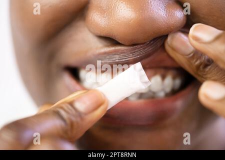 Donna masticare umido umido fumo tabacco Snus prodotto Foto Stock