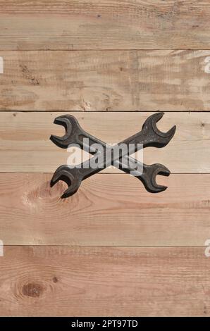 Un paio di chiavi arrugginito su un sfondo di legno. Obsoleti gli strumenti domestici fatta di metallo arrugginito giacciono su di un tavolo di legno in un workshop. Il concetto di una riparazione Foto Stock