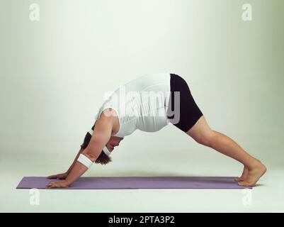 Im la sensazione in luoghi che non sapevo di avere. Un uomo in sovrappeso che fa yoga Foto Stock