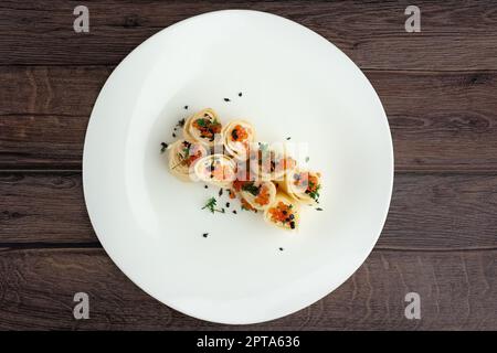 Vista dall'alto di frittelle con salmone e caviale sulla grande piastra bianca Foto Stock