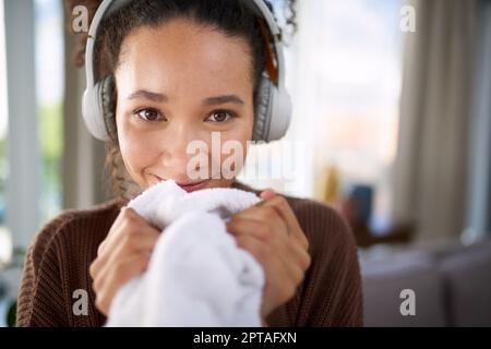 Che cosa mi rende felice l'odore del mio ammorbidente del tessuto. una donna che odora il bucato appena lavato mentre si siede a casa Foto Stock