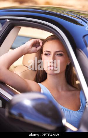 Im a casa dietro il volante. Una donna seduta in un'auto di lusso Foto Stock