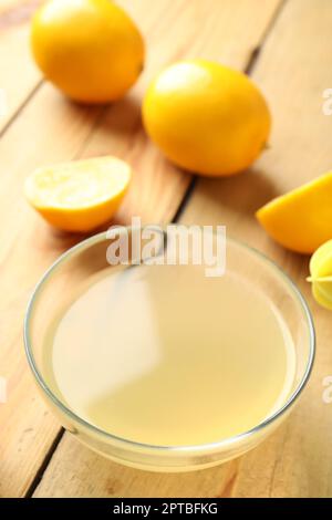 Spremuta di limone fresca in una ciotola su un tavolo di legno Foto Stock