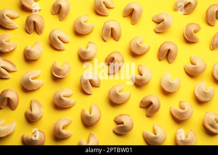 Molti biscotti gustosi della fortuna con le previsioni su fondo giallo, giacimento piatto Foto Stock