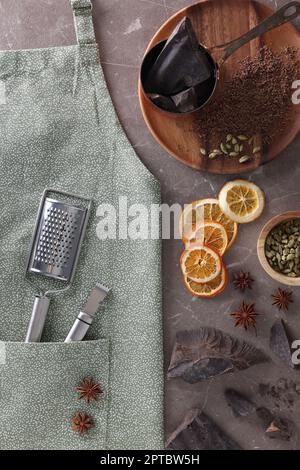 Pulire il grembiule con utensili da cucina e ingredienti diversi su un tavolo in marmo marrone, piatto Foto Stock