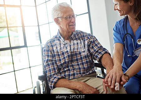 Il relativo grande avere un'infermiera che realmente si preoccupa. un'infermiera che parla con un paziente anziano nella casa di riposo. Foto Stock