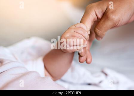 Quando un bambino afferra il dito, inestimabile. madre che tiene la mano dei neonati Foto Stock