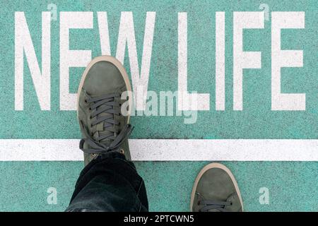 Uomo che attraversa la linea, iniziando nuova vita. Camminando attraverso la linea di partenza che rappresenta il concetto di start up di vita e di affari. Nuovo inizio, nuovo inizio. Foto Stock