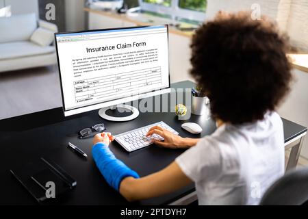 Copertura di risarcimento danni al lavoratore con braccio rotto. Utilizzo di un portatile Office Foto Stock