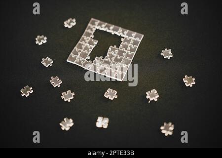 Primo piano di un puzzle con pezzi trasparenti. Foto Stock