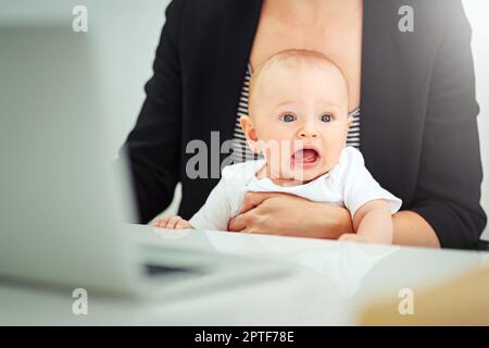 Mamma, chiudi il notebook e lascia giocare. una donna d'affari che si sta occupando del bambino mentre lavora sul suo laptop Foto Stock