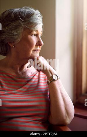 Alcuni ricordi non sbiadiscono mai. una donna anziana che guarda premurosa Foto Stock